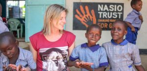 Children holding Nasio volunteers hand